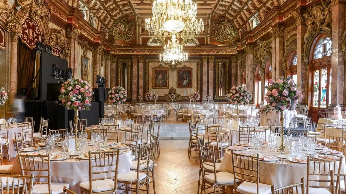 Interior del Salón de los Reyes en el Casino Español con mesas, candelabros y pinturas.