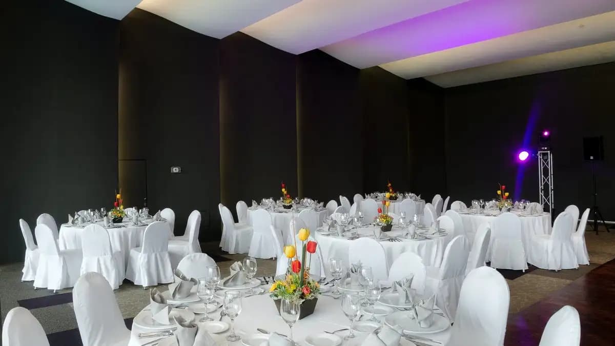 Fotografía del Salón Covadonga en el Parque Asturias. Se ve un centro de mesa y mesas circulares. Montaje para evento en el Salón Covadonga.