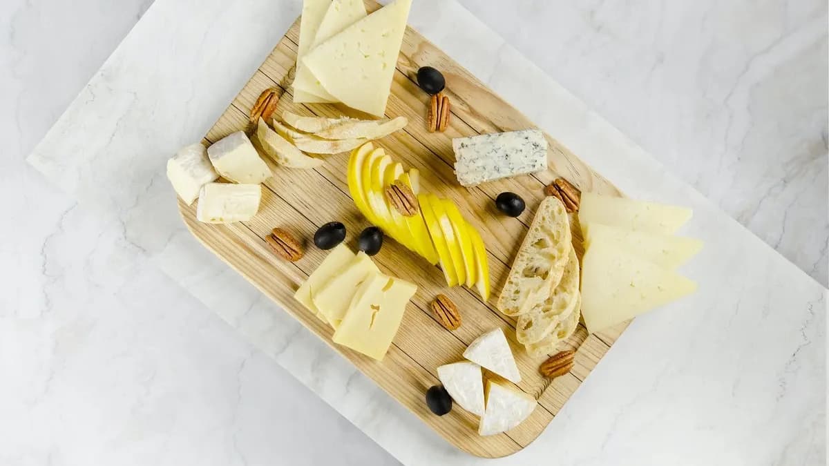 Tabla de quesos españoles con manzana, aceituna, y nueces