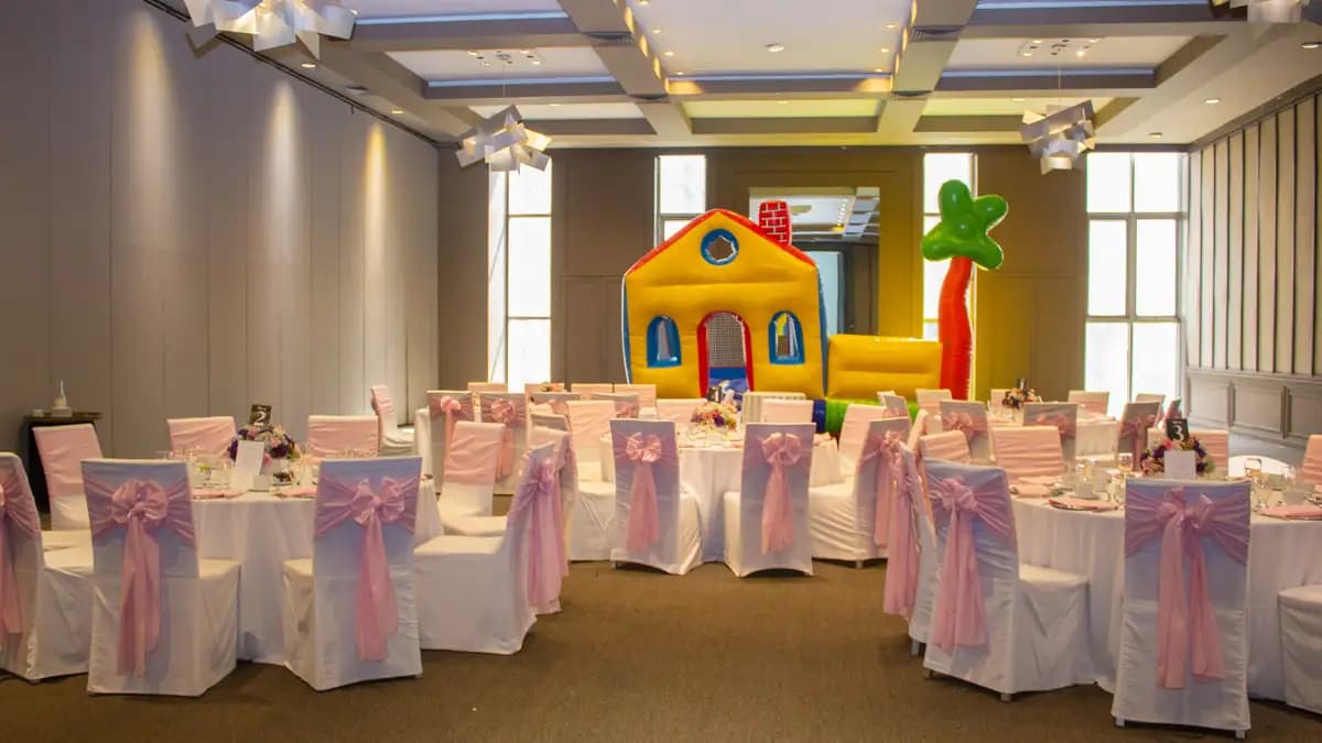 Salón Ciudad de México del Asturiano Polanco. Mesas circulares con centros de mesa. Tiene toques dorados. Hay un inflable para fiestas infantiles.